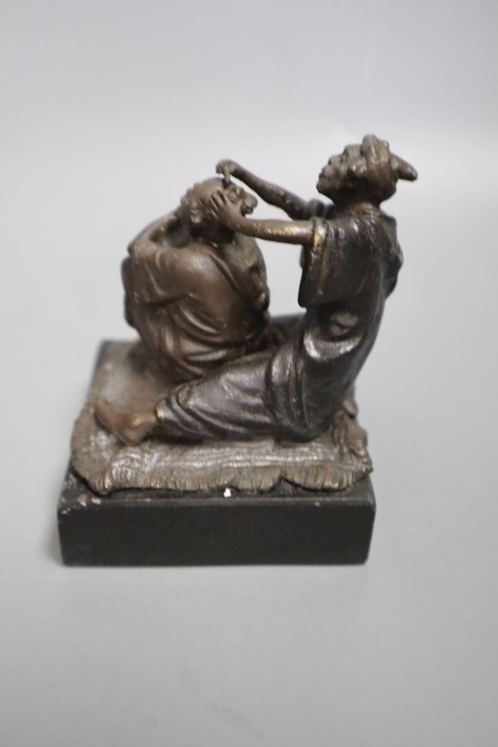 A cast metal sculpture Kiss after Rodin, height 14cm and another of Arabs